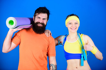 Exercising together is fun. Healthy lifestyle concept. Man and woman exercising with yoga mat and...