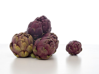 Raw artichokes, Mediterranean vegetable, uncooked on white.