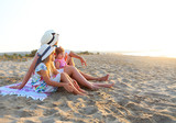 Laughing family with father, mother, daughters having picnic at the beach