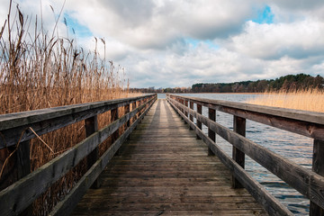 Naklejka premium wooden pier at waterside - straight wood dock walkway at lake