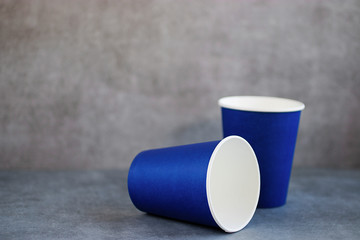 Two blue paper cups on a gray background.
