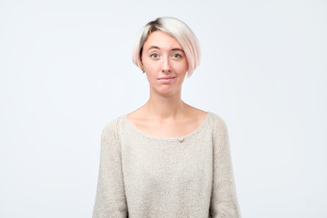 Doubt, mistrust, distrust concept. Doubtful woman looking with disbelief expression at studio.