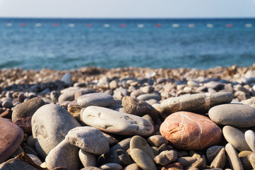 Pebbles on the shore and the sea horizon