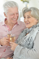Portrait of mature couple drinking champagne at home, close up