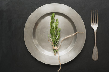 Vintage table place setting with rosemary on black. Top view. Concept. Minimalism
