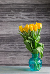 yellow tulips on a dark wooden background