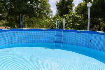 The blue pool is half filled with water.