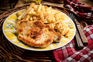 Pork chop, french fries and vegetables.