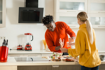Man cooking in the kitchen and refusing taking spices