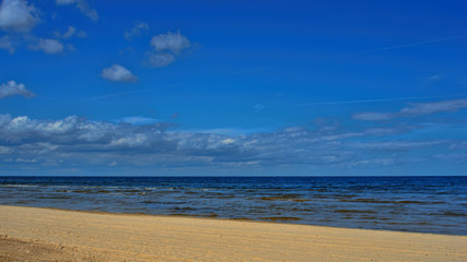 Fototapeta na wymiar Landscape background with light clouds over Baltic sea near shoreline, selective focus
