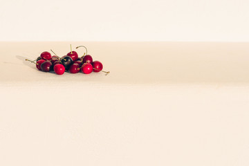 Ripe sweet cherry on a white stone bench on a sunny summer evening
