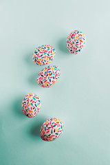 Funny multicolored easter eggs hand painted with brushes, on soft blue background