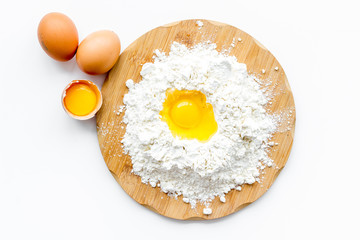 Making dough concept. Pile of flour and eggs on white background top view