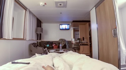 Time lapse of couple lying in bed on ferry while watching television