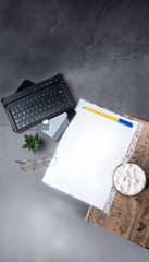 coffee with pen, white papper, glasses, stapler, cactus, coffee and laptop, credit card on concrete table with newspaper
