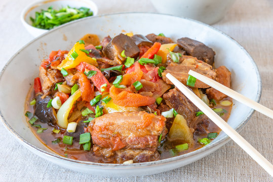 Fried pork with eggplants and sweet peppers in a large bowl - a traditional Chinese dish