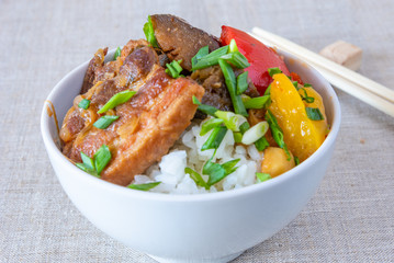 Bowl of rice with spicy pork and vegetables close up - traditional asian dish