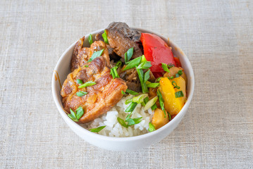 A bowl of rice with pork, eggplant and sweet pepper - a traditional Japanese dish