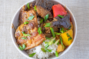 Bowl of rice with spicy pork and vegetables close up - traditional asian dish