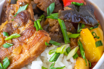 Bowl of rice with spicy pork and vegetables close up - traditional asian dish