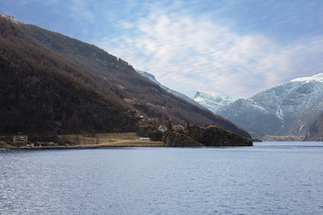 Beautiful Nature view in Norway . During travel Bergen , Lofoten islands , Norwegian fjord and Winter landscape with buildings, snowy mountains, sea, purple cloudy sky .