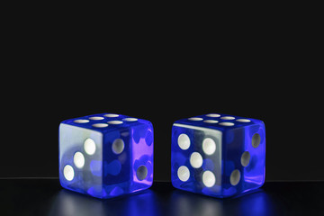 Two blue glass dice on a polished wooden table on a gray background with copy space. Six and six.