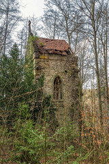 Fototapeta na wymiar small abandoned gothic chapel in the woods