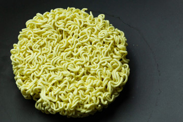 The Instant noodle on black ceramic plate close up.