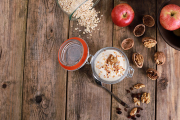 light healthy breakfast  with yogurt on oatmeal muesli and walnuts in a glas on a rustic wooden table. close up