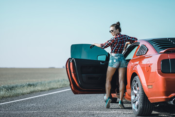brunette girl posing near the car