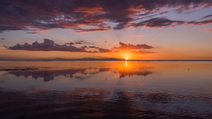 Fototapeta premium sunset at a beach, the sea in low tide, a tranquil scene in a summer evening vacation mood 
