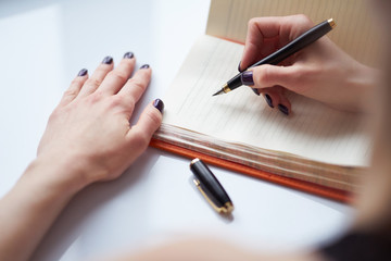woman's hand writing notes in diary