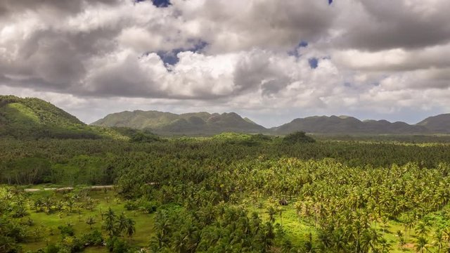 Beautiful nature view the palm trees and hills in the clouds at summer day near General Luna in Siargao island, Philippines. Aerial Drone Timelapse 4K