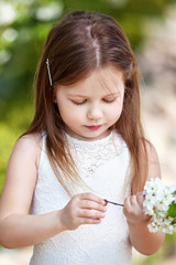 Pretty  little girl in cream dressin the blossom garden