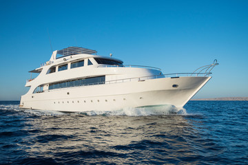 Luxury motor yacht sailing out on tropcial sea