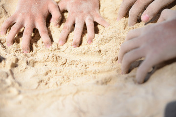 Children hands playing sand on the beach. Summer day concept. Happy kids on vacations at seaside.