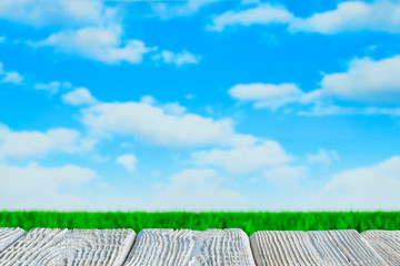 Rural landscape - wooden board, lawn and blue sky background