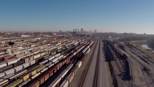 Fly over large train yard with city in distance