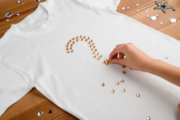 Girl puts rhinestones on t-shirt