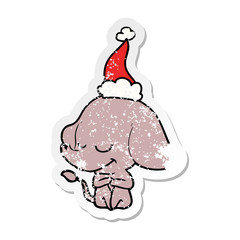 distressed sticker cartoon of a smiling elephant wearing santa hat