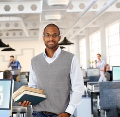Intelligent black man at office holding books