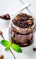 Homemade cosmetics with scrub and coffee beans on desk background