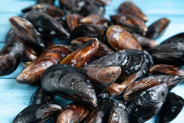 Fresh raw mussels on blue wooden backgound