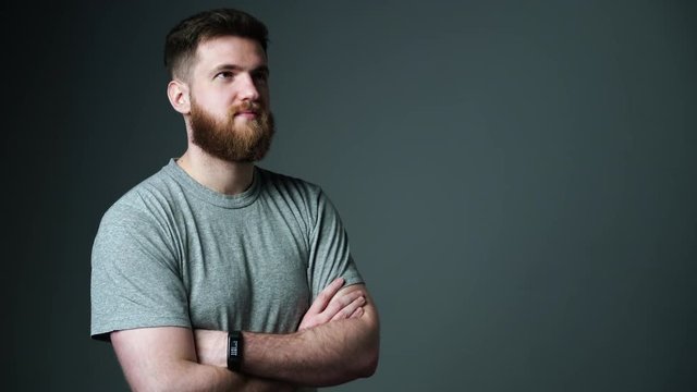 Half length portrait of young bearded hipster man looking at blank copy space