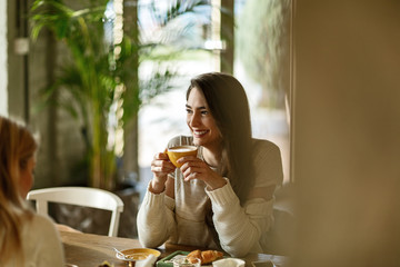Young happy woman drinking coffee and relaxing in a cafe.