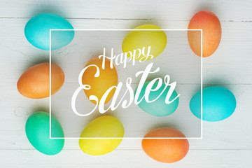 colored Easter eggs on a white table, top view