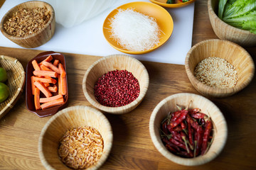 Above view background of various spices in wooden bowls on table