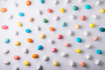 Colored eggs flat lay on a white background. Easter and spring composition.