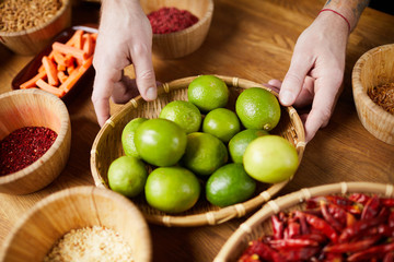 Close up of unrecognizable man holding lime bowl while cooking spicy food, copy space