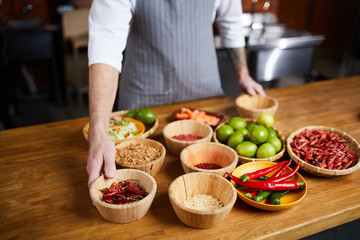 Mid section portrait of professional chef choosing aromatic spices while cooking in restaurant kitchen, copy space
